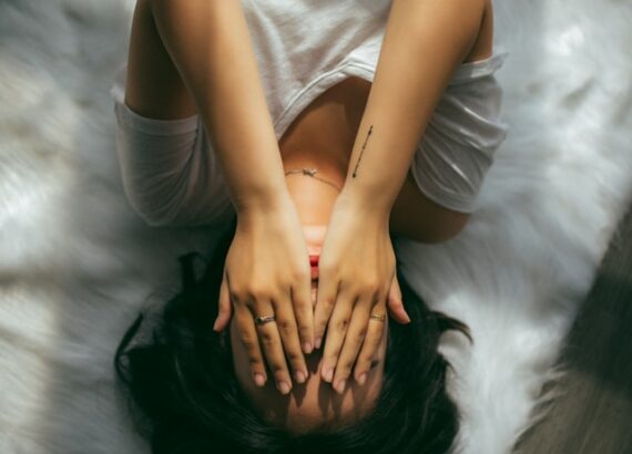 Image of woman laying down looking stressed. This image could depict someone who is needing counseling for anxiety in North Carolina. Get connected with an anxiety therapist in Charlotte, nc to get started online!