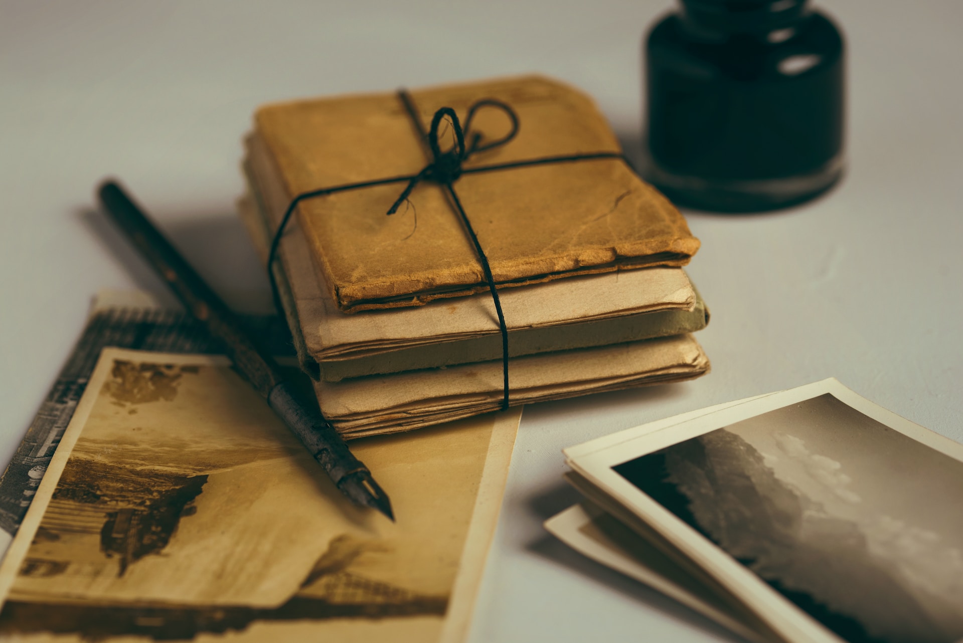 A bundle of old photos and documents tied by a simple black string. Family history. Pregnancy support. Anxiety treatment near me.