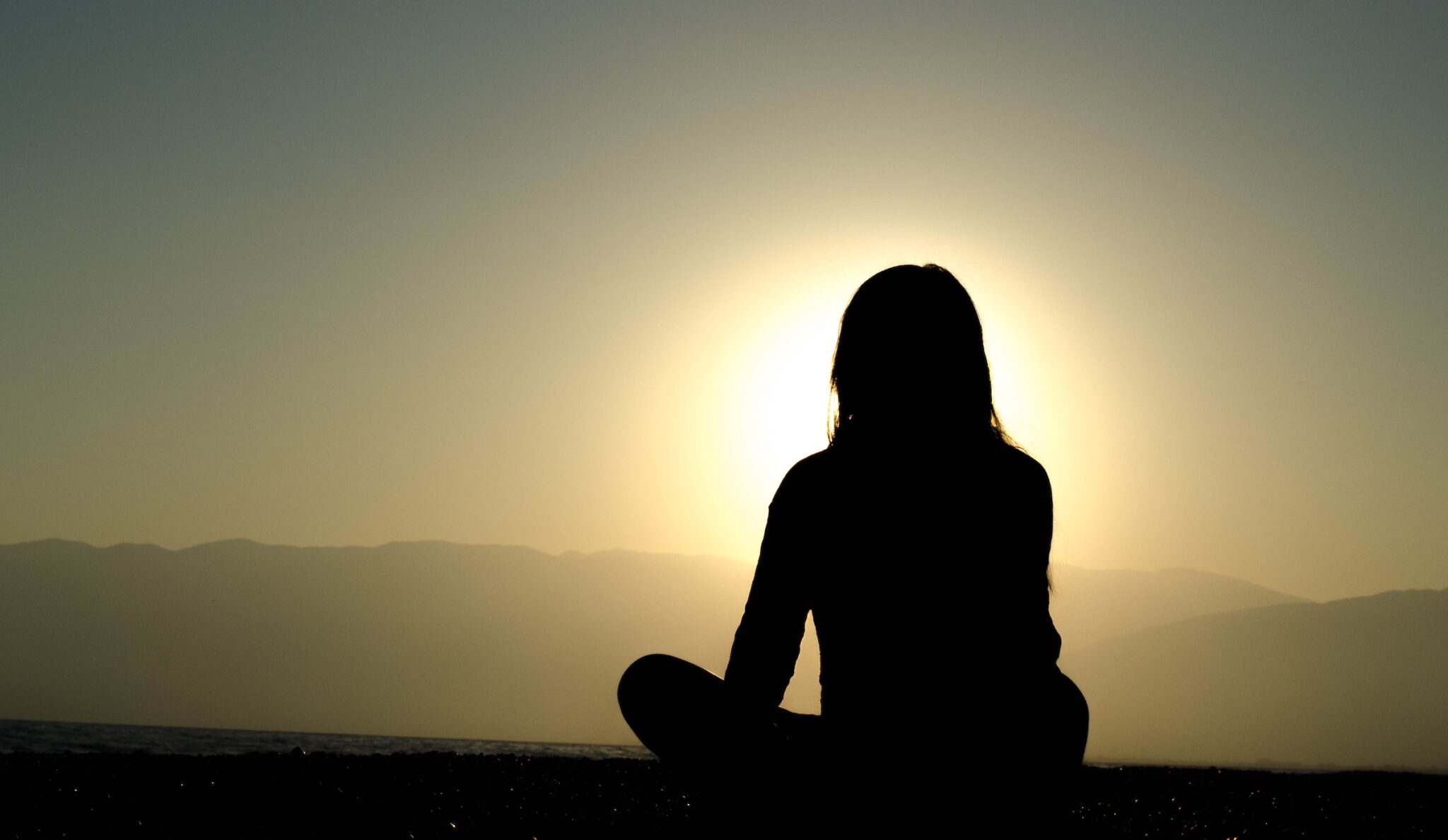 Woman outside at sunrise meditating. Cognitive behavioral therapy charlotte nc. Counseling to recover from emotional trauma.