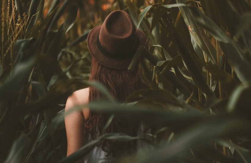 Woman with ADHD in a field wearing a hat. Attention-deficit/hyperactivity disorder therapy. Counselor for ADHD.