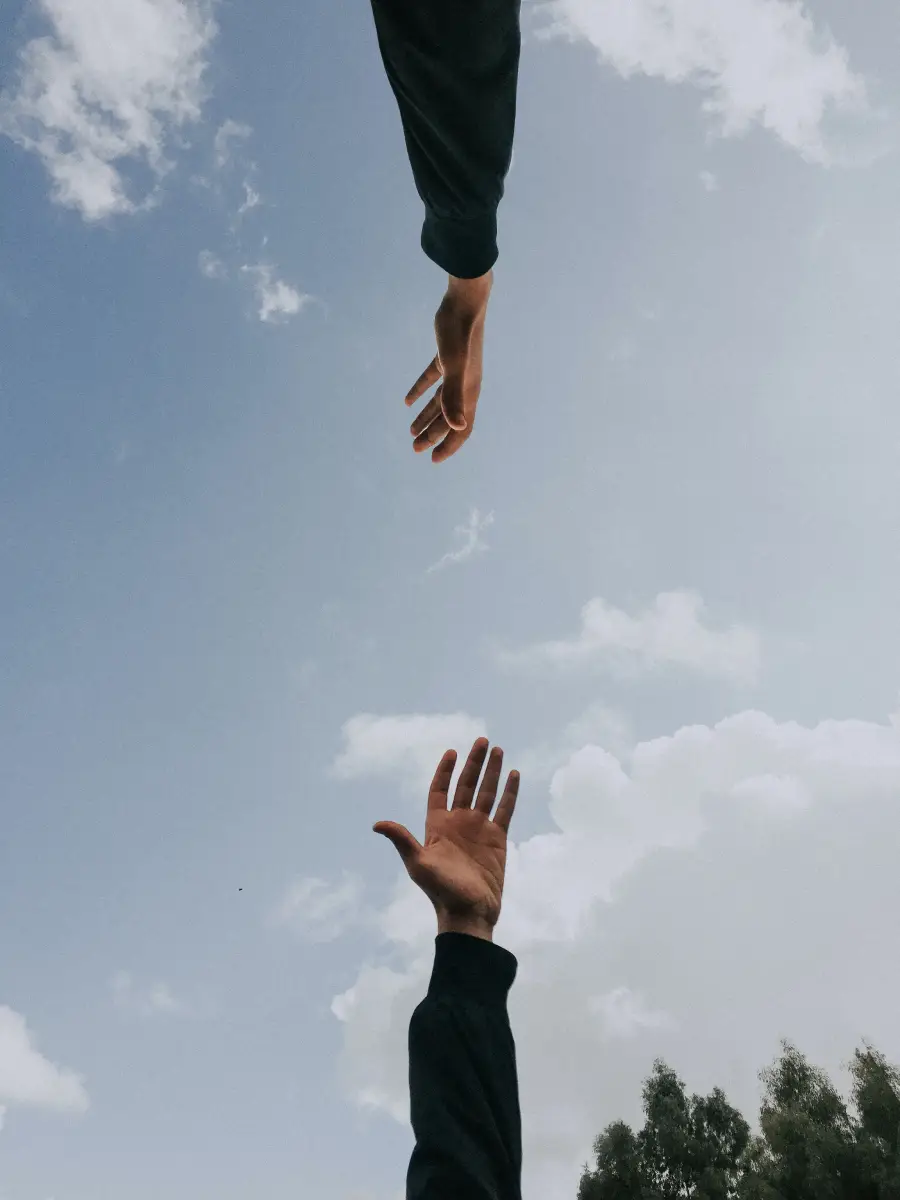 Two hands reaching up towards the sky, symbolizing hope and aspiration.