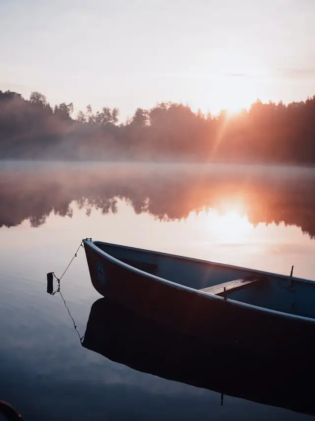 A boat on calm water during sunrise, symbolizing tranquility and peace. Perfect for Anxiety Treatment.