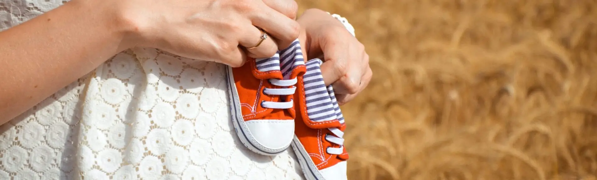 A woman holding orange and white shoes, representing postpartum and perinatal mental health counseling.