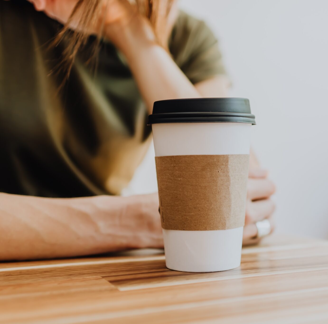 Woman with coffee sitting at table. Trauma informed therapist near me. Wilmington NC. Cary NC. EMDR.