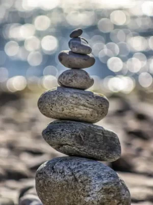 Stones artfully stacked on a beach, creating a sense of calmness and equilibrium. Symbolic of counseling.